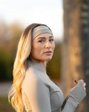 Woman wearing a gray headband with a blurred natural background