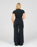 Woman wearing a black jumpsuit on a white background