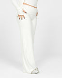 Person wearing a white outfit with a high slit on a light gray background