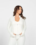 Woman wearing a white outfit against a plain background