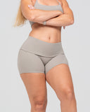 Person wearing a gray sports bra and shorts on a light gray background