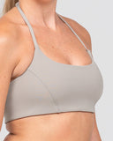Gray sports bra worn by a person on a light gray background
