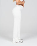 Person wearing a white outfit with wide-leg pants on a light gray background