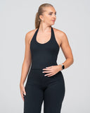 Woman wearing a black athletic outfit on a gray background 