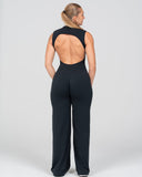 Black open-back jumpsuit worn by a model on a white background