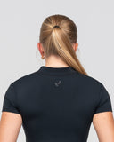 Person wearing a black shirt with a logo on a light gray background